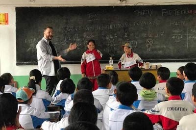 a male ESL teacher in his classroom with kids